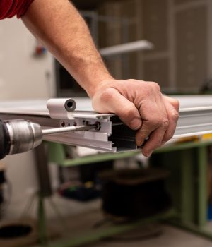 A male with a red shirt making a window with industrial tools